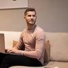 Man sitting on a couch using a laptop in a modern living room.